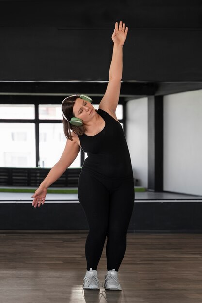 Fotografía completa de una mujer bailando en el estudio.