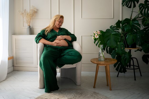 Fotografía completa de una mujer embarazada pasando tiempo en el interior