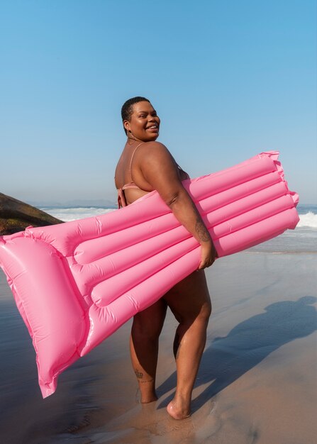 Fotografía completa de una mujer de tamaño grande posando en la orilla del mar
