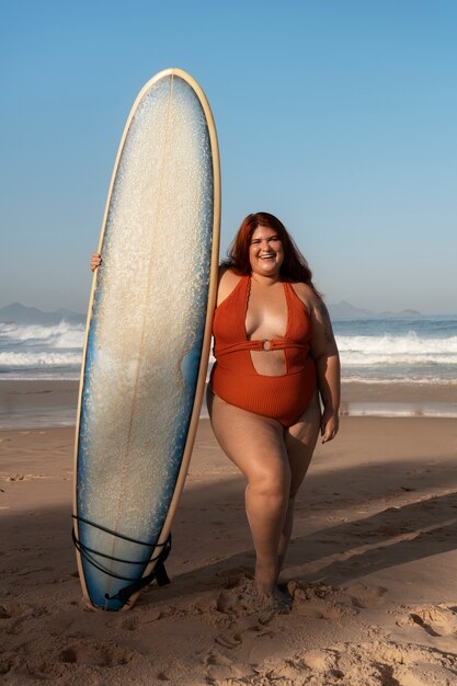 Fotografía completa de una mujer de tamaño grande posando en la orilla del mar