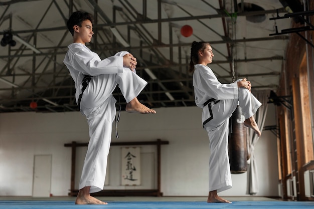 Fotografía completa de personas asiáticas practicando taekwondo