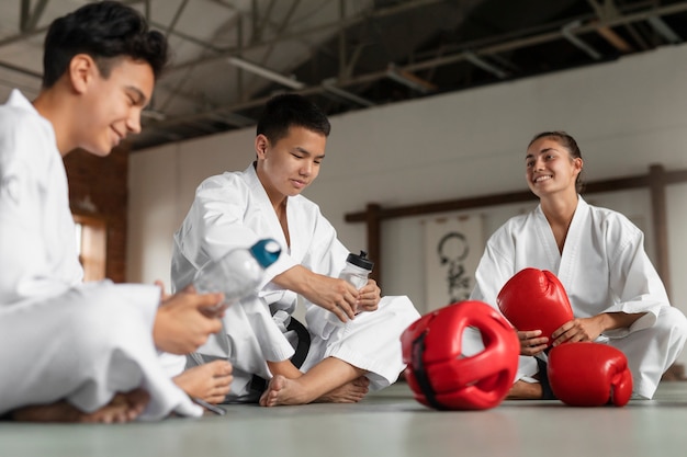 Fotografía completa de personas asiáticas practicando taekwondo