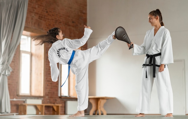 Foto gratuita fotografía completa de personas asiáticas practicando taekwondo