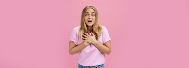 Foto gratuita fotografía interior de una chica guapa con camiseta y vaqueros con las palmas de las manos en el corazón.