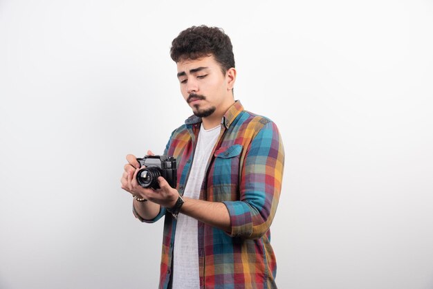 Fotografía joven con experiencia tomando fotos profesionales de manera seria.