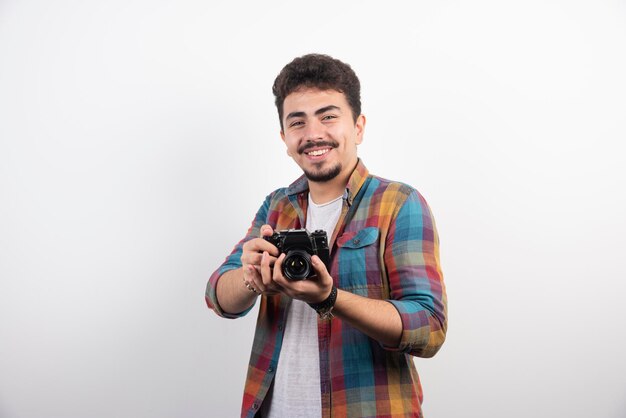 Fotografía joven con experiencia tomando fotos profesionales de manera seria.