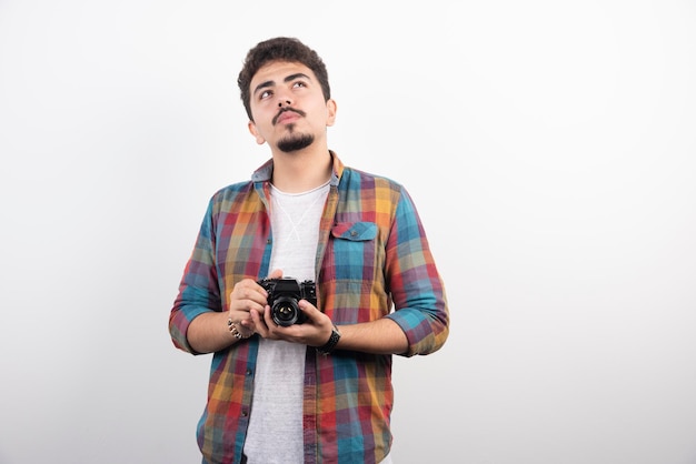 Fotografía joven con experiencia tomando fotos profesionales de manera seria.