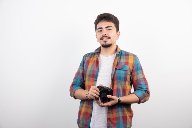 Fotografía joven con experiencia tomando fotos profesionales de manera seria.