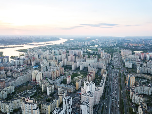 Foto gratuita fotografía panorámica aérea desde la vista de pájaro del dron al distrito de pozniaky y vista a la orilla derecha del dnieper con puentes a través de él y el edificio moderno de la ciudad de kiev