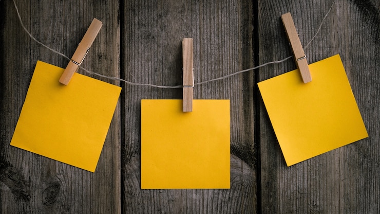 Foto gratuito fotografía en primer plano de un papel amarillo colgado en un clips de madera
