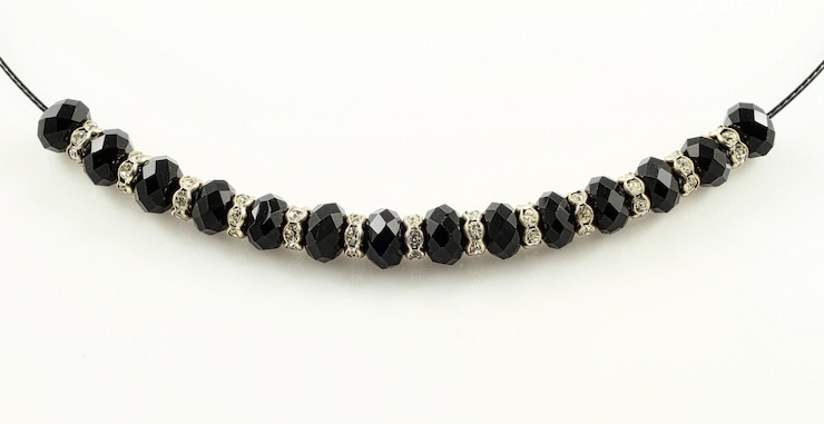 Foto gratuito fotografía en primer plano de una pulsera con cuentas negras brillantes aisladas sobre un fondo blanco en el estudio