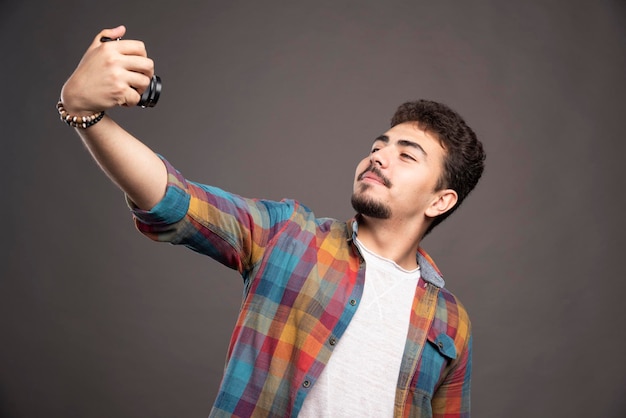 Fotografía tomando sus selfies de manera positiva con una cámara.