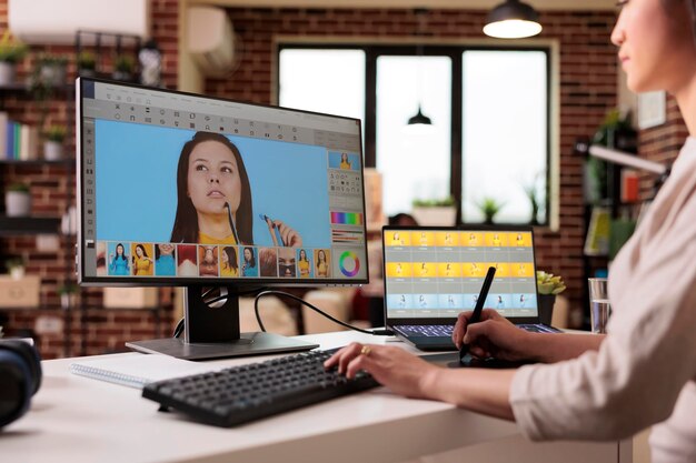 Fotógrafo asiático editando imágenes con software de retoque en la computadora. Trabajando con la interfaz de retoque para editar fotografías artísticas con gradación de color y contraste visual, producción multimedia.
