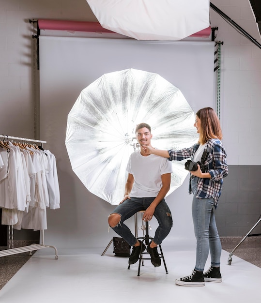 Foto gratuita fotógrafo ayudando al hombre en cómo posar para la foto