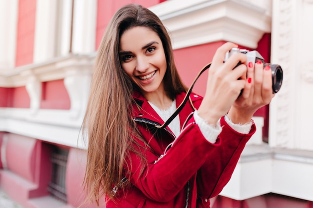 Fotógrafo de ensueño con manicura de moda trabajando al aire libre y riendo