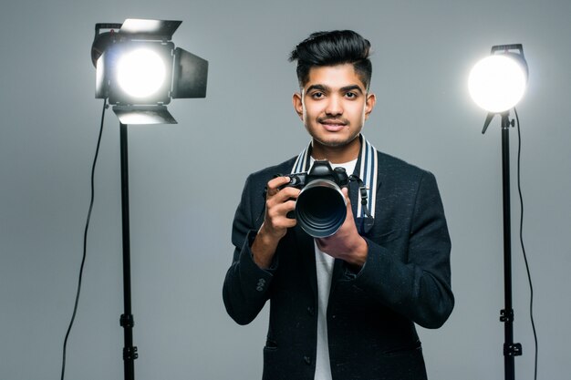 Fotógrafo joven indio profesional tomando fotos en estudio con leight