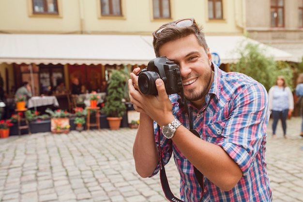 Fotógrafo joven tomando fotografías, tomando fotos con cámara digital a sus amigos