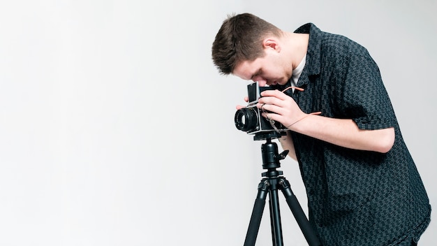 Fotógrafo mirando a través de la cámara con espacio de copia