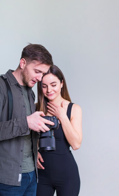 Fotógrafo y modelo femenino revisando fotos en cámara.