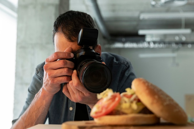 Foto gratuita fotógrafo de producto con cámara en estudio