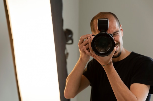 Foto gratuita fotógrafo de productos masculinos haciendo su trabajo en el estudio.