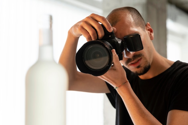 Foto gratuita fotógrafo de productos masculinos haciendo su trabajo en el estudio.