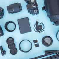 Foto gratuita fotógrafo profesional de accesorios y equipos dispuestos sobre fondo azul.