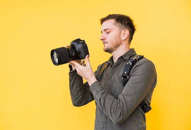 Fotógrafo de sexo masculino que mira la pantalla de la cámara