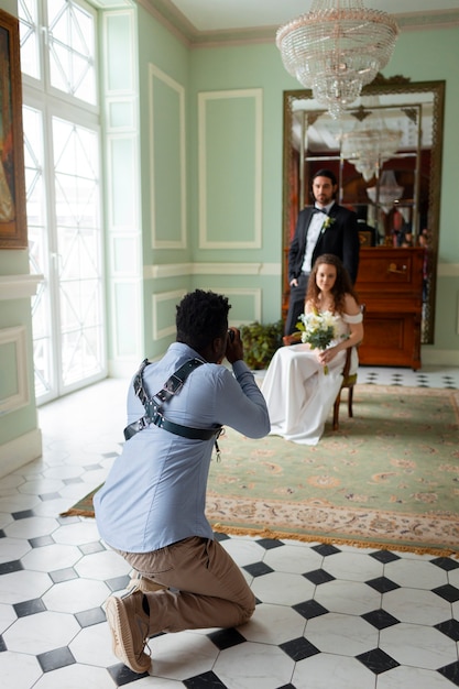 Foto gratuita fotógrafo de tiro completo y pareja casada.