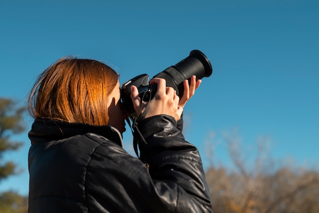 Fotógrafo de tiro medio con cámara