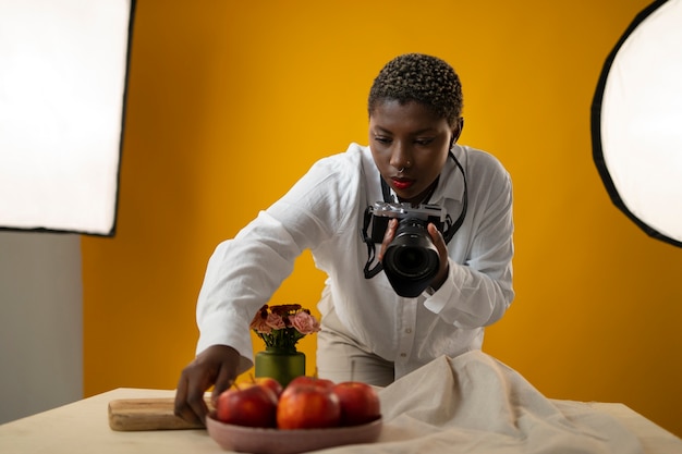 Fotógrafo de tiro medio tomando fotos de frutas.