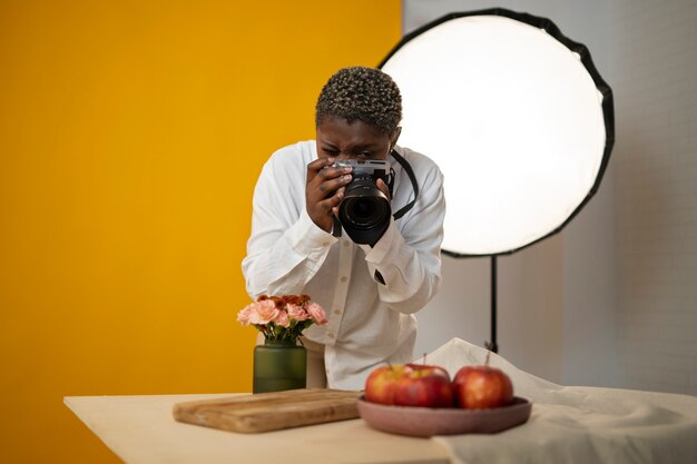 Fotógrafo de tiro medio tomando fotos de frutas.