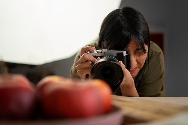 Foto gratuita fotógrafo de tiro medio tomando fotos de frutas.