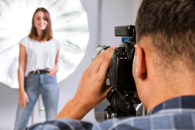 Fotógrafo tomando una foto de una mujer modelo en estudio