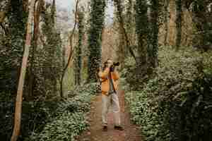 Foto gratuita fotógrafo tomando fotos en el bosque al aire libre