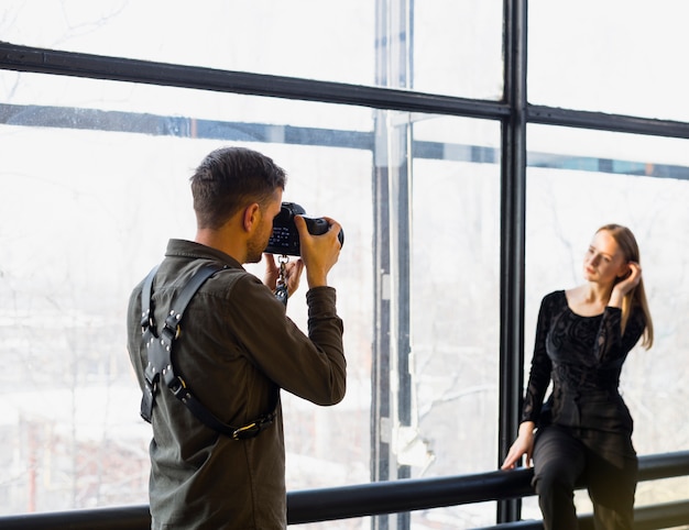 Fotógrafo tomando fotos de joven modelo femenino.