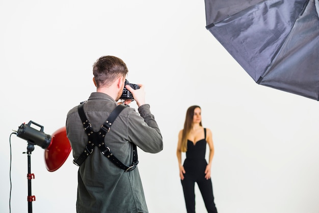 Fotógrafo tomando fotos de modelo en estudio