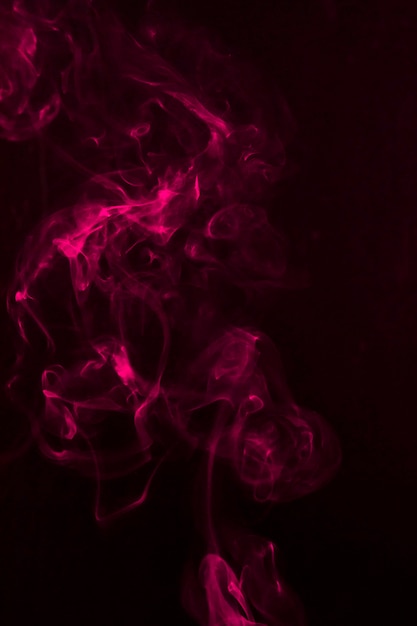 Fragmentos de humo rosa sobre un fondo negro