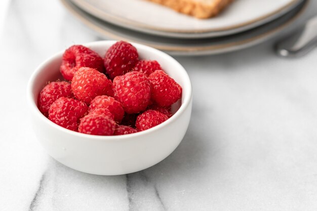 Frambuesas frescas en la mesa para el desayuno