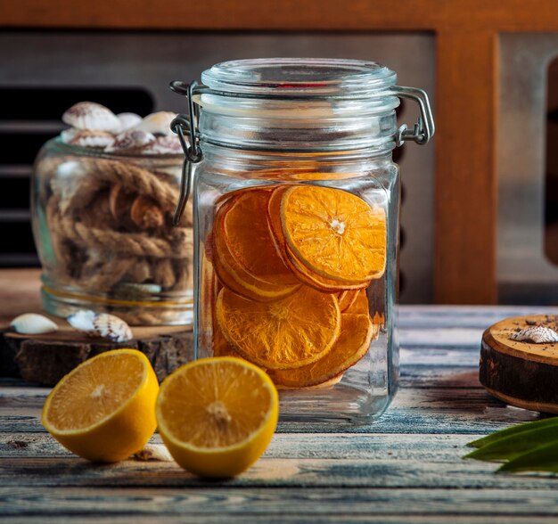 Frasco de vidrio hermético con rodajas de naranja seca