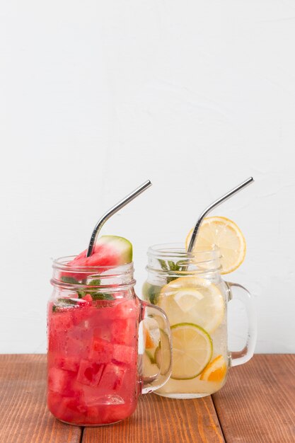 Frascos con bebidas de frutas frescas en la mesa