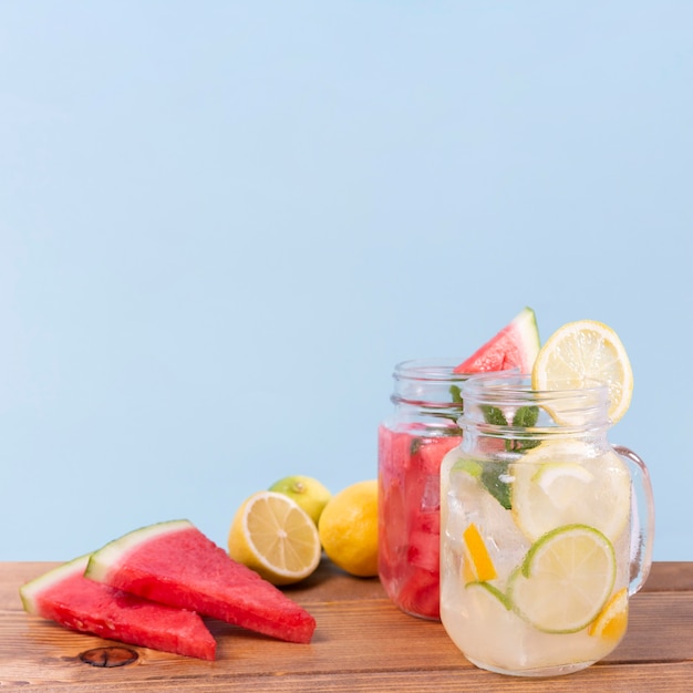 Frascos con bebidas de frutas frescas en la mesa