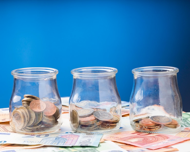 Foto gratuito frascos con monedas en billetes