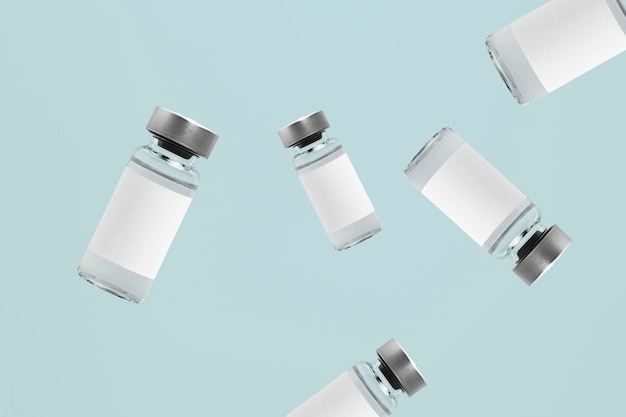 Foto gratuita frascos de vidrio de vial de inyección que caen con etiquetas blancas