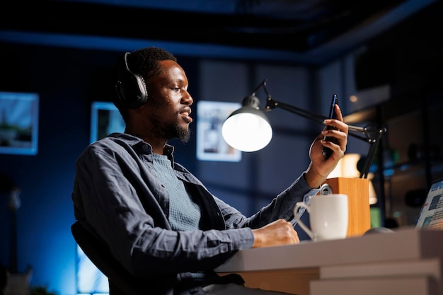 Foto gratuita un freelance afroamericano responde una videollamada telefónica