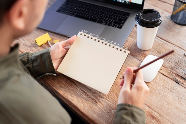 Freelancer de alto ángulo tomando notas