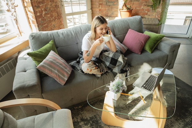 Foto gratuita freelancer mujer caucásica durante el trabajo en la oficina en casa mientras está en cuarentena