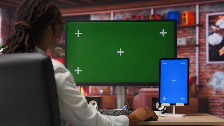 Foto gratuito freelancer en la oficina de su casa usando una pc de pantalla verde y una tableta de maqueta