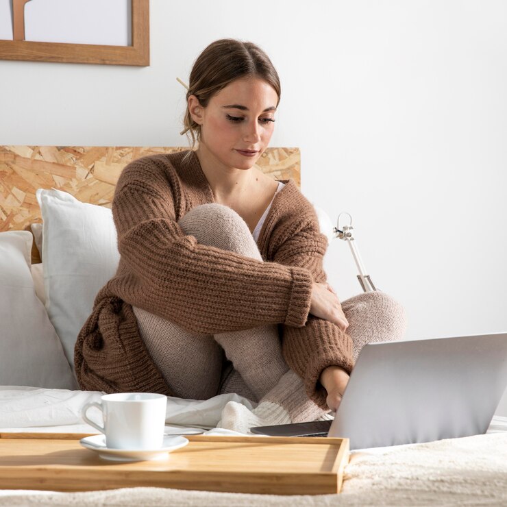 Foto gratuito freelancer de tiro completo trabajando en la cama