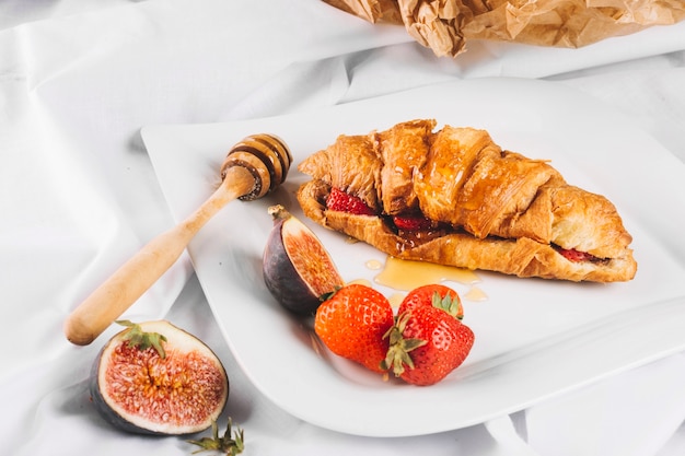 Fresa e higo cerca de un buen croissant